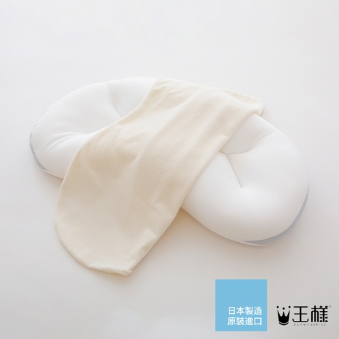 白色嬰兒定型枕，外層鋪有米白色軟布，枕頭兩側有淺灰色滾邊，呈現彎月形。