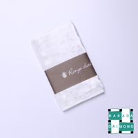 白色毛巾一條，中間有咖啡色包裝紙，上面印有「Range cloth」字樣和茶壺圖案。