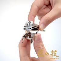 一雙手正在操作一個銀色金屬材質的指甲剪，指甲剪上有防飛濺集屑的設計，整體呈銀色，在白色背景下展示。