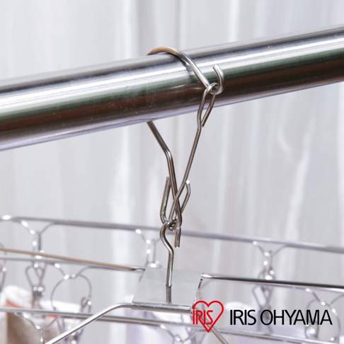 不鏽鋼曬衣夾，銀色，由金屬製成，帶有三個夾子，懸掛在金屬桿上，背景為白色布簾，右下角有「IRIS OHYAMA」標誌。