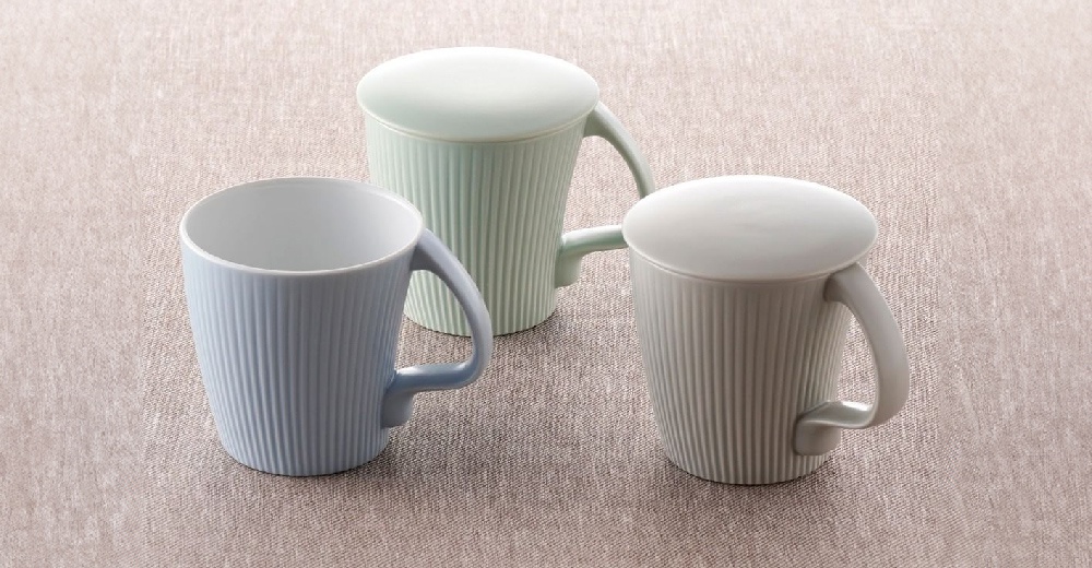 三款叉腰馬克杯，分別為淺藍色、淺綠色和白色，皆帶有杯蓋。杯身為垂直條紋設計，材質看似陶瓷。