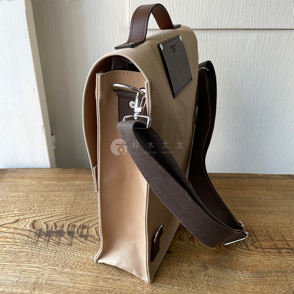 犬印純綿帆布三用直式側背包，米色帆布搭配咖啡色皮革提把與肩帶，銀色金屬釦具，簡潔設計。