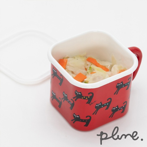 紅色琺瑯材質的方形保鮮罐，帶有把手，罐身印有黑色小貓圖案。罐內盛有切塊的白菜和胡蘿蔔。附有一個白色方形蓋子。