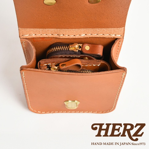 職人手作皮革經典腰袋，淺棕色牛皮材質，內有兩個拉鍊小零錢包，以黃銅釦固定。