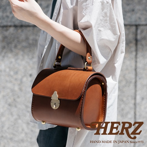 棕褐色皮革復古手提包，設有金色鎖扣和金屬腳釘。