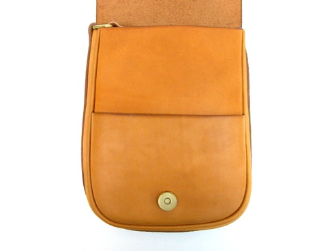 職人手作皮革翻蓋直式單肩包，採用原色皮革製作，翻蓋設計，正面有雙層口袋，底部有金色按扣。