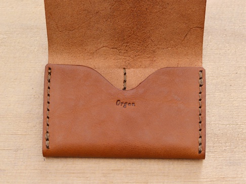 職人手作皮革Organ薄型名片短夾，呈現自然棕色皮革紋理，手工縫線細緻，翻蓋內側印有「Organ」燙金字樣。