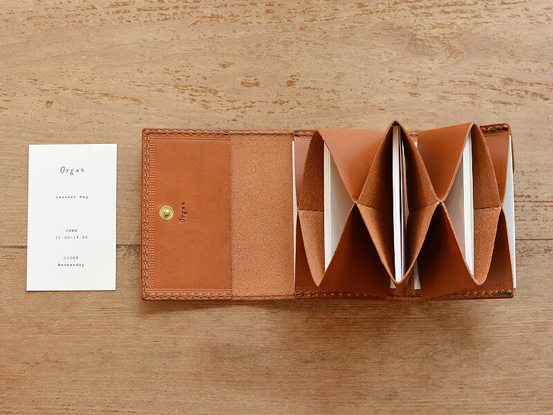 寬版棕色皮革證件收納夾，內部為風琴式多層隔間，可收納多張證件或卡片，夾身設有品牌壓紋及金色按扣。