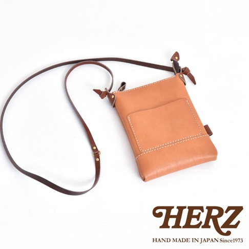 職人手作皮革直式隨身單肩包，淺棕色皮革，附有長背帶，包身有縫線裝飾及外層口袋。