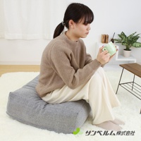 灰色紋理布料製成的方形坐墊，內部填充飽滿，質感柔軟。