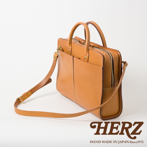 職人手作皮革雙口袋兩用商務公事包，淺棕色皮革，設有雙前口袋、拉鍊主隔層、頂部提把及可拆卸肩帶。