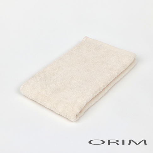 一件米白色、柔軟的今治浴巾，材質為純棉，毛圈紋理清晰，邊緣有縫線。