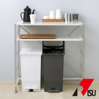 SOLOW 踩踏對開分類垃圾桶，左為白色，右為深灰色，皆為 35L 容量，配備踏板，置於白色層架下方。