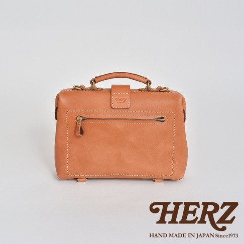 職人手作淺棕色皮革迷你軟皮杜勒斯包，圓潤提把，正面有拉鍊口袋，簡約設計，適合搭配各種風格。