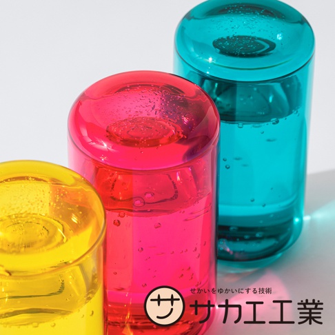 SAKAE UENOSUKE SHITANOSUKE 兩用蓋杯-L 共有三款鮮豔的顏色：黃色、桃紅色和青綠色，每個杯子都裝有液體，並帶有細小的氣泡，在柔和的光線下呈現半透明的效果。