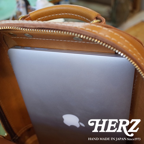 職人手作皮革立體商務後背包，展示內層空間，可放入筆記型電腦，皮革材質，焦糖色。