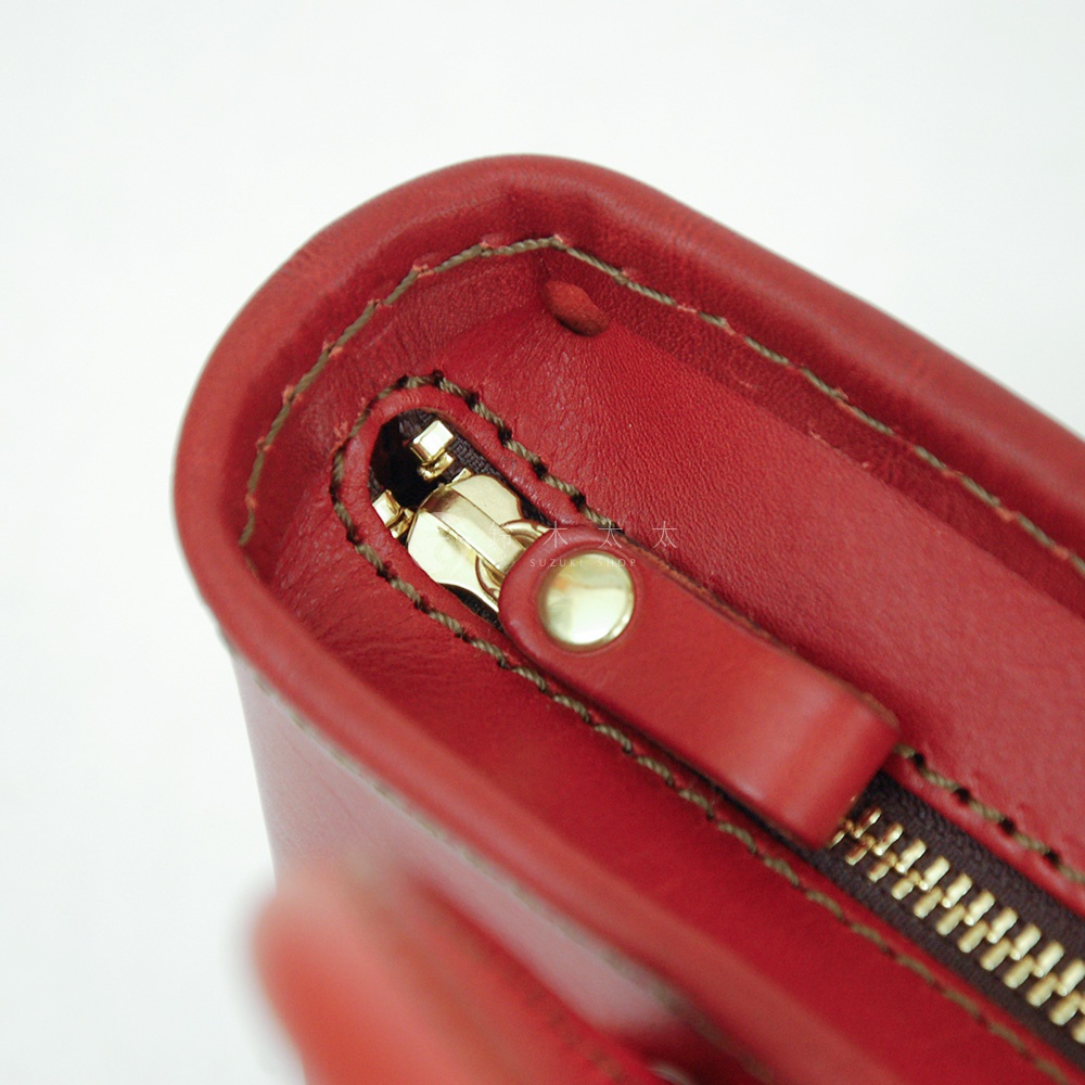 職人手作皮革輕巧散步手提包 Q-1，紅色皮革材質，配有金色拉鍊和同色皮革拉頭，車縫線明顯。