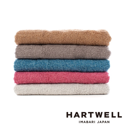 一疊五條不同顏色的毛巾，由上至下分別是：褐色、灰色、藍色、粉紅色、淺灰色。毛巾材質柔軟，紋理清晰。