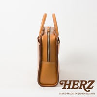 職人手作皮革雙口袋兩用商務公事包，採用天然皮革製成，呈現溫潤的焦糖棕色。包款設有雙口袋設計，並配有堅固的拉鍊和提把，風格簡約實用。