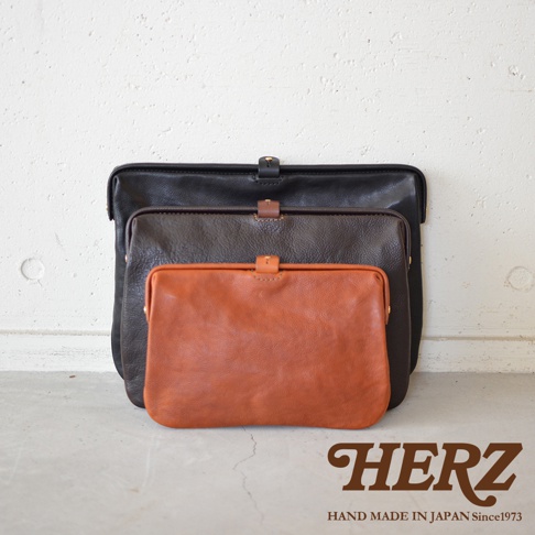 職人手作皮革Organ手拿包，展示三種尺寸的黑色、深棕色和橘棕色皮革包款，皆為簡約的長夾設計，搭配金屬扣環。