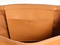 職人手作皮革原子釦托特包 (T-43)，內部特寫，呈現天然棕色皮革材質，內有縫線分隔的置物袋，品牌標誌壓印於袋面。