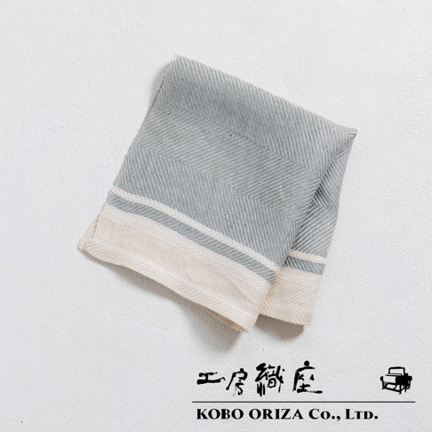 一條淺藍色純亞麻斜紋廚房拭巾，帶有米白色和淺藍色條紋邊緣，材質柔軟，質感精緻。