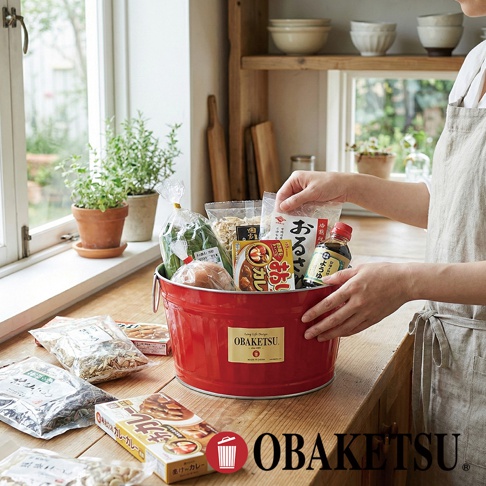 OBAKETSU 復古紅色手工迷你收納桶，盛裝著各種食材，擺放在木質檯面上，背景是明亮的窗戶和綠色盆栽。