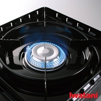 黑色卡式爐，爐頭中央有藍色火焰，爐架結構為黑色金屬材質，邊緣有方形開孔設計。