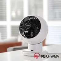 白色圓形空氣循環扇，黑色扇網，配有IRIS OHYAMA 標誌，放置於白色底座上，背景為模糊的室內裝潢。