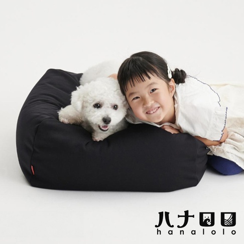 一位小女孩與一隻白色捲毛小狗依偎在黑色的方形懶骨頭沙發上，畫面風格溫馨簡潔，右下角印有日本hanalolo品牌標誌。