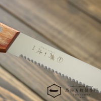 [堺一次] 不鏽鋼麵包刀，茶色木柄，鋸齒狀不鏽鋼刀刃，刀身上印有品牌標誌及「sakai ichiji」字樣。