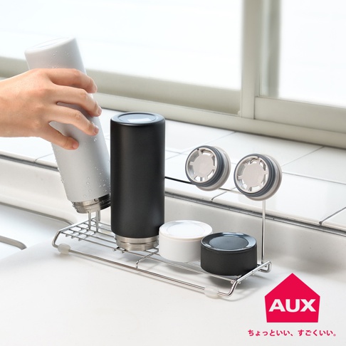 不鏽鋼瓶壺瀝水架，包含一個銀色保溫瓶、一個黑色保溫瓶，以及兩個白色和黑色的瓶蓋。瀝水架為金屬製，設計簡潔，可放置於廚房檯面。