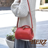 紅色職人手作皮革口金醫生單肩包，包身圓潤，配有頂部提把及可拆卸斜背帶，細膩縫線與金屬釦件增添質感。