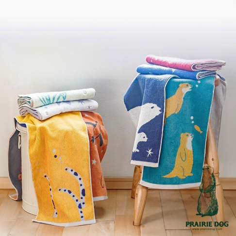 堆疊的今治毛巾，有動物刺繡圖案，包括水獺和北極熊。顏色為藍色、綠色、白色、黃色和粉紅色，材質為柔軟的棉質。