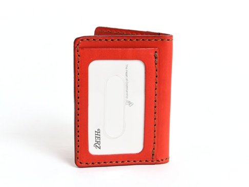 亮紅色皮革三面雙折票券夾，正面有一個透明卡套，並飾有品牌標誌和手工縫線。