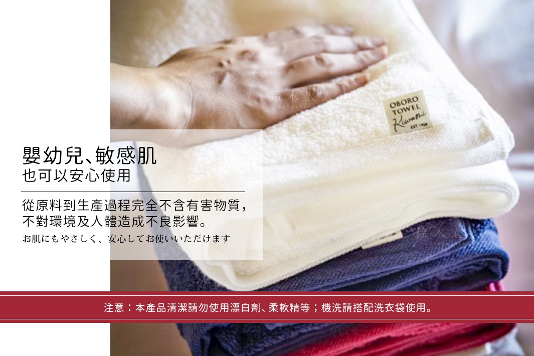 疊放的細纖浴巾，有白色、深藍色和紅色。其中一條白色浴巾上疊著一隻手，另一條白色浴巾上有「OBORO TOWEL Kuwamis」的標籤。