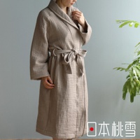 身著淺褐色雙面紗布立體織紋輕質浴袍的女性。浴袍有領子、腰帶，材質呈現細緻的紋理。