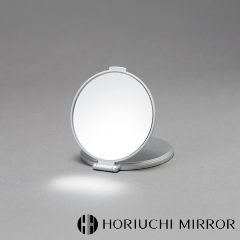 堀內鏡 HORIUCHI MIRROR 的 Napure 隨身口袋3倍放大小圓鏡，銀色金屬材質，可折疊，置於灰色背景上，鏡面上方帶有品牌標誌。