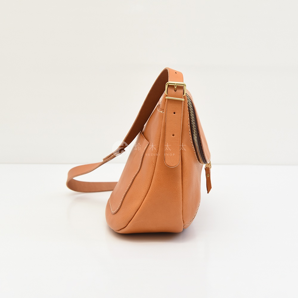 日本 HERZ 職人手作皮革大容量馬鞍包 CK-150，淺棕色牛皮側背包，以精緻縫線和簡約設計呈現，可見金屬拉鍊和可調節的皮質肩帶。