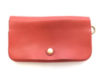 紅色皮革製的長夾，正面有一個金色鈕扣，右側邊緣有一個金屬環。