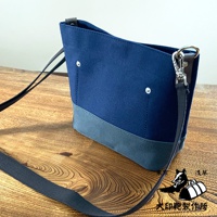 犬印純綿帆布迷你側背包，採用深藍色帆布與淺灰色帆布拼接設計，配有黑色織帶和銀色金屬扣環。