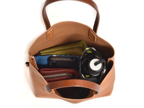 職人手作皮革直式軟皮托特包，淺棕色，內部可見手機、錢包、綠色和藍色內袋，以及一個黑色波點圖案的摺疊傘。