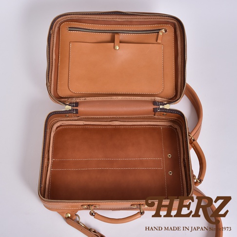 職人手作皮革兩用商務後背包 R-33，展示其打開的狀態，內部分層清晰，採用自然棕色皮革，帶有精緻縫線與金色拉鍊。