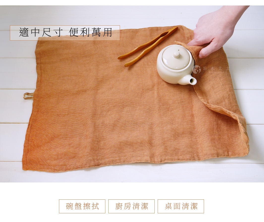 一張橘棕色三層蚊帳棉織廚房拭巾，上面放著一個白色茶壺和木夾，拭巾質感輕薄，邊緣有縫線。