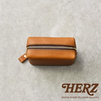 一個棕色皮革製的拉鍊收納包，上面壓印著 Organ 字樣，底部有 HERZ 品牌標誌和 HAND MADE IN JAPAN Since1973 字樣。