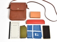 職人手作皮革橫式隨行袋 (CP-9) 為棕色皮革材質，設計簡約，附有可調節式長背帶，另有卡夾、筆袋、筆記本、鑰匙包、手帕及手機等配件。