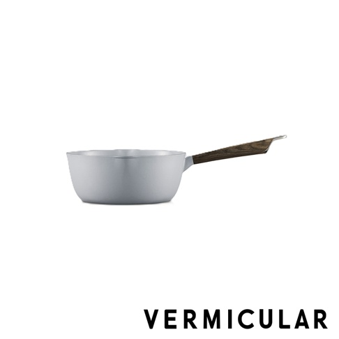 VERMICULAR琺瑯鑄鐵雪平鍋，鍋身呈現簡約的淺灰色調，搭配質感深褐色的木紋長柄，側面視角展現圓潤洗鍊的鍋體設計，下方標示著品牌名稱。