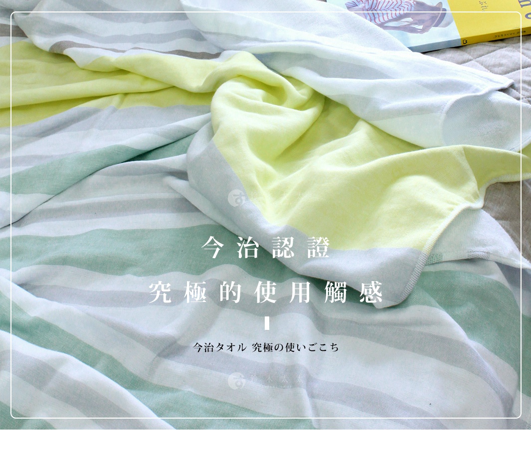 今治毛巾被，帶有柔和的灰、綠、黃色條紋，質地柔軟，鋪展在床上。