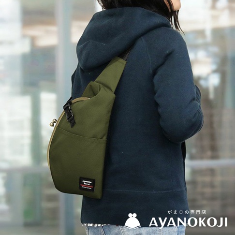 一個斜背著橄欖綠 Sarei 機能布水滴型口金斜背包的女子，斜背包上有 AYANOKOJI 品牌標籤，下方為 AYANOKOJI 品牌 Logo。