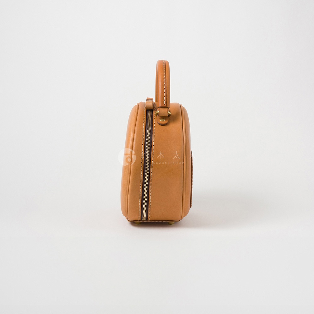 日本HERZ職人手作皮革兩用圓形包 Q-13 焦糖色，以側視角度呈現，可見其圓潤的包身及精緻的縫線細節。